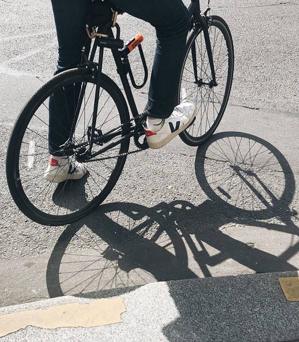Homem andando de bicicleta com tênis da Vert