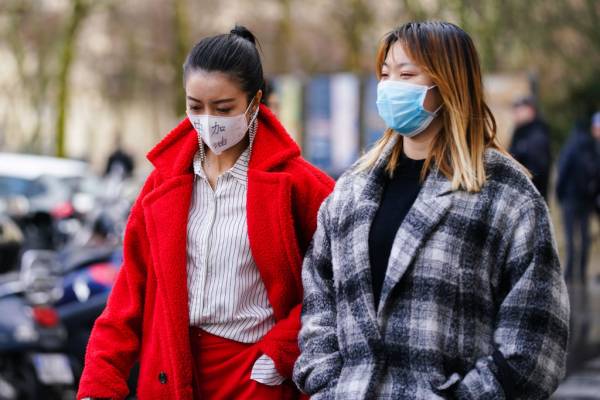 mulheres usando máscara descartável na rua por causa do coronavírus