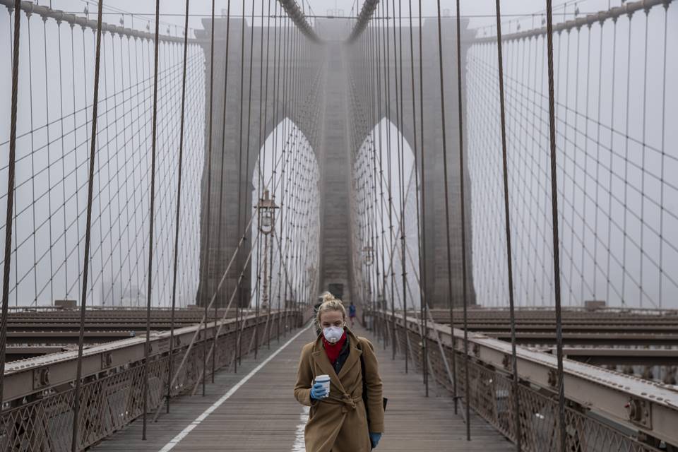 Mulher caminha de máscara na Brooklyn Bridge em Nova York em meio à pandemia do novo coronavírus (Covid-19)