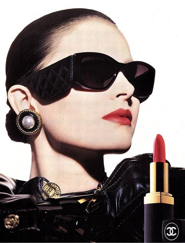 Modelo com óculos e batom vermelho ropaganda de beleza da Chanel