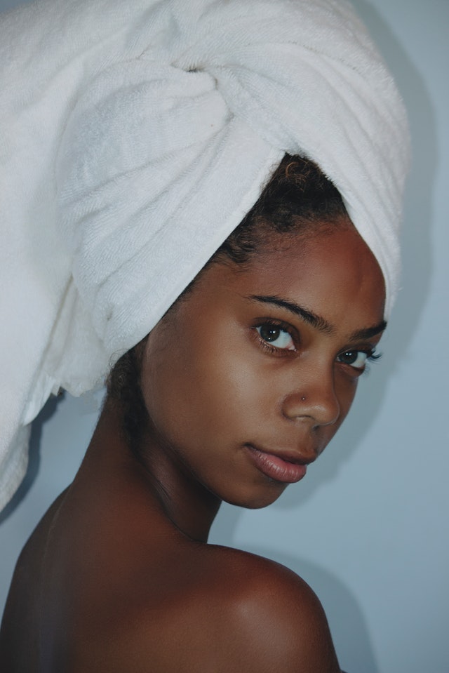 mulher negra com toalha no cabelo