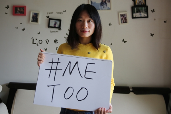 Sophia Huang Xueqin posa com um cartaz #MeToo em sua casa