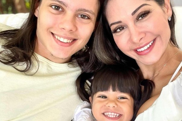 Fotografia colorida de Maíra com os dois filhos