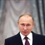 De frente, Vladimir Putin fala em evento com fundo acinzentado atrás - Metrópoles