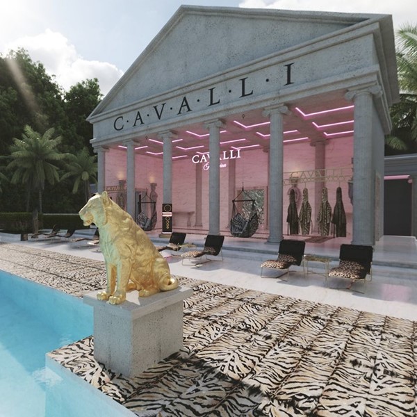 Região externa de uma casa de luxo com uma piscina azul, uma estátua de um leão dourado e uma área gourmet com pilastras em estilo grego