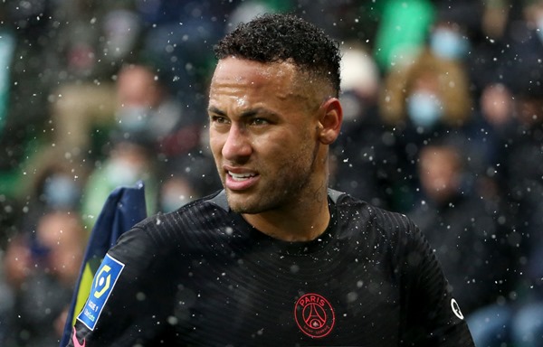 Neymar Júnior, jogador brasileiro de futebol. Ele tem cabelos escuros, usa uniforme de time de futebol e olha seriamente para a frente - Metrópoles