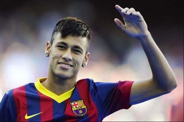 Neymar Júnior, jogador brasileiro de futebol. Ele tem cabelos escuros, usa uniforme de time de futebol e olha seriamente para a frente - Metrópoles