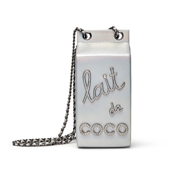 Bolsa Chanel imitando caixa de leite. Ela possui alça fina de metal e couro e é branca, com escritos em cristais "Lait de Coco" - Metrópoles