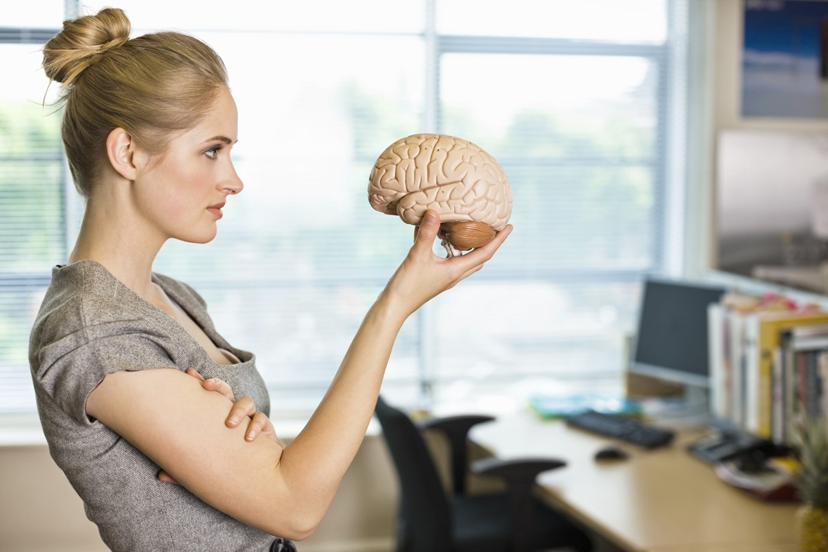 Mulher segurando objeto e formato de cérebro