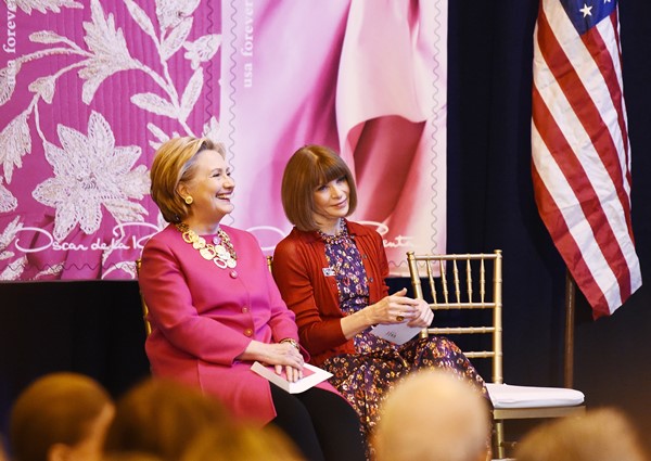 A ex-primeira dama dos Estados Unidos, Hillary Clinton, em evento com Anna Wintour, editora de moda da revista Vogue. Ela estão em um evento do estilista Oscar de La Renta, em 2017. As duas são mulheres idosas, de pele branca, com cabelo curto e louro.