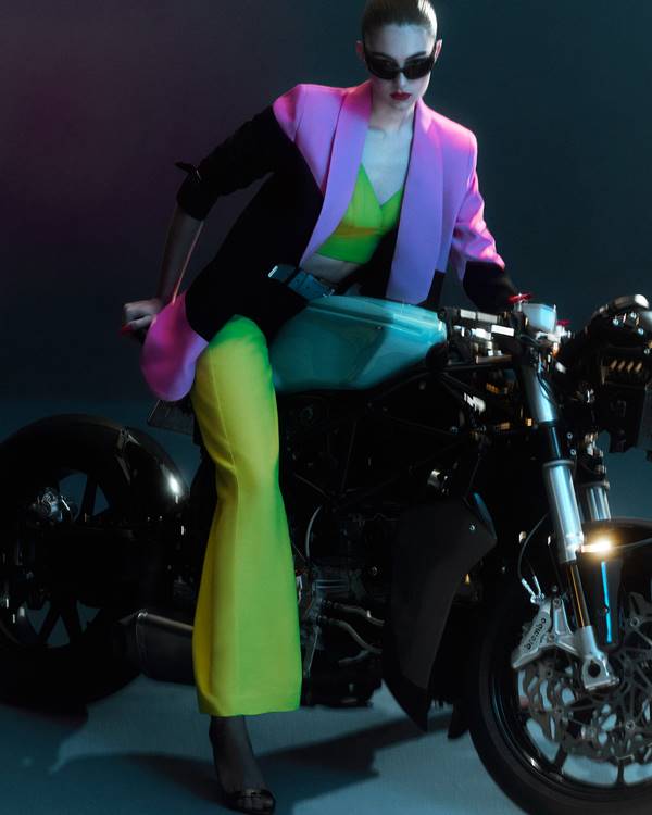 Look colorido usado por modelo sentada em moto, em editorial da coleção Special, da Shop Ginger