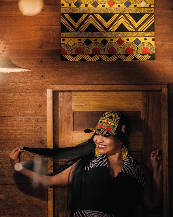 Na imagem com cor, mulher indígena posa para foto