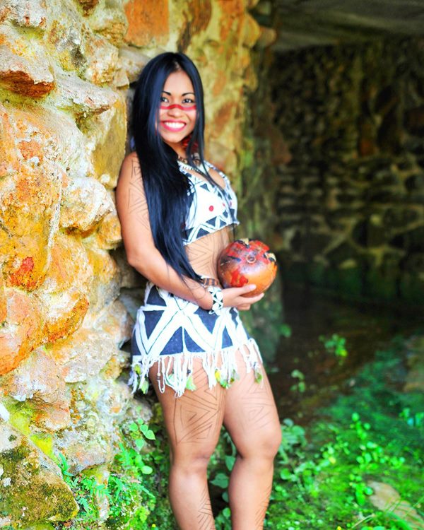 Na imagem com cor, mulher indígena posa para foto