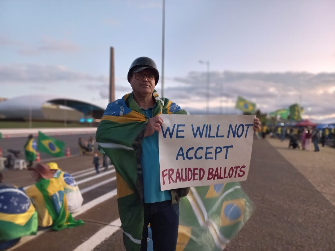 Bolsonarista com cartaz em inglês dizendo que não aceita resultado das eleições