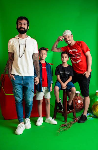 Fotografia colorida mostra quatro homens, de diferentes idades, sendo duas crianças e dois jovens, usando combinações de peças de roupas para as festas de fim de ano-Metrópoles