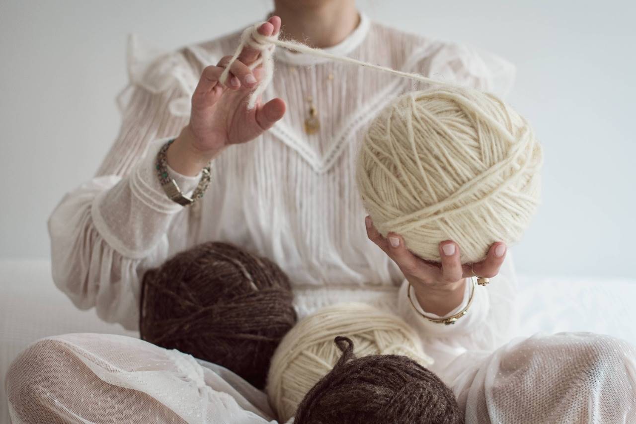 Mulher segurando quatro novelos de lã | Metrópoles