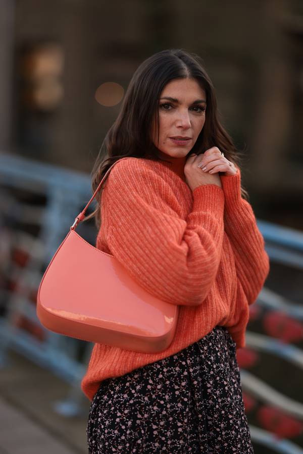 No street style, mulher usa suéter laranja - Metrópoles