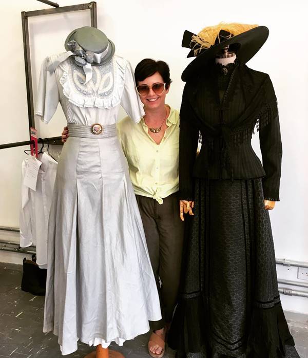 Alice Alves ao lado de dois manequins vestidos com roupas de época - Metrópoles 