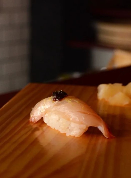 Foto de uma fatia de peixe em um bolinho de arroz - Metrópoles