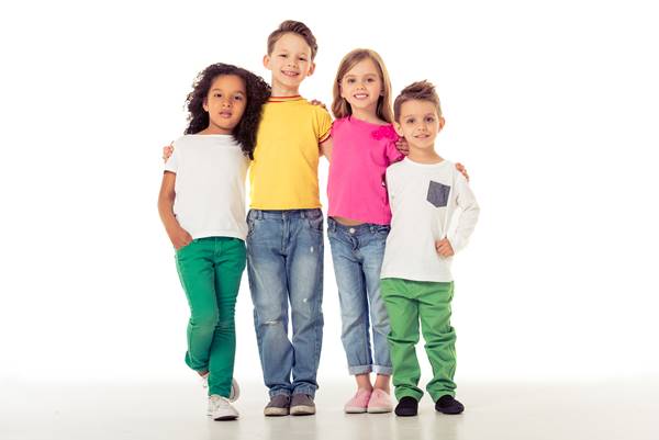 Grupo de crianças posando para foto em fundo branco - Metrópoles
