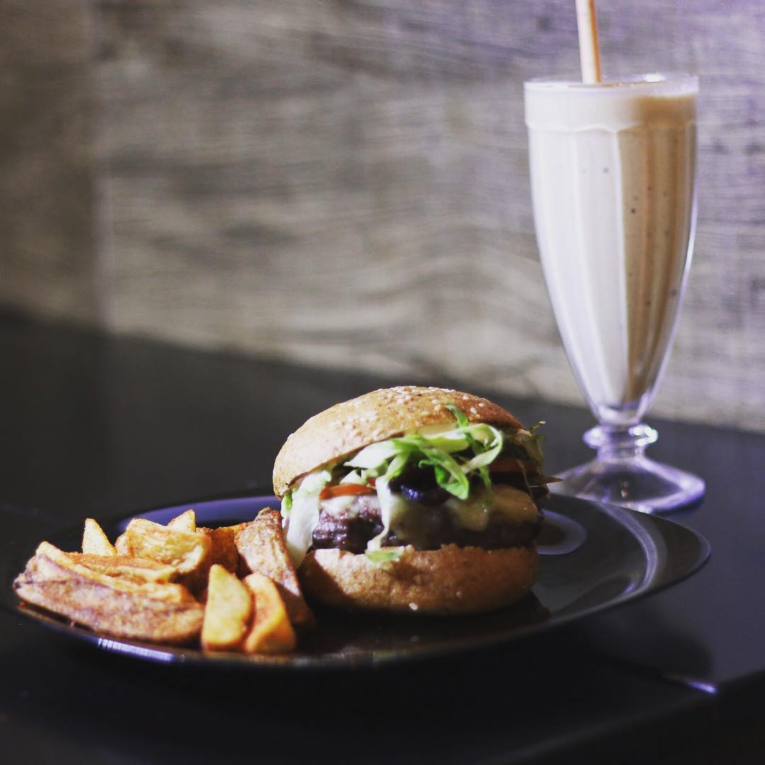 Na foto, um prato com hambúrguer, batata e milk-shake - Metrópoles