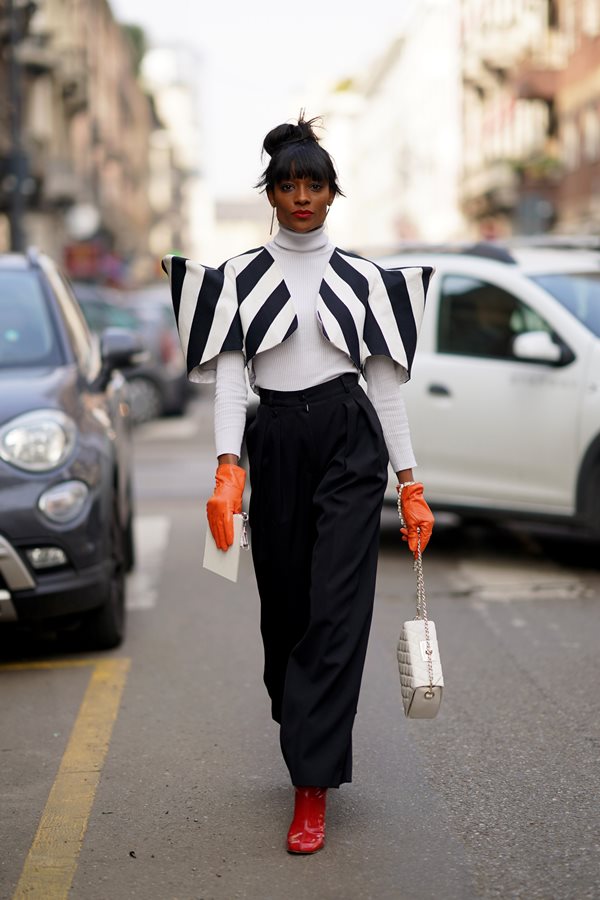 Mulher andando na rua com roupas preto e branco - Metrópoles