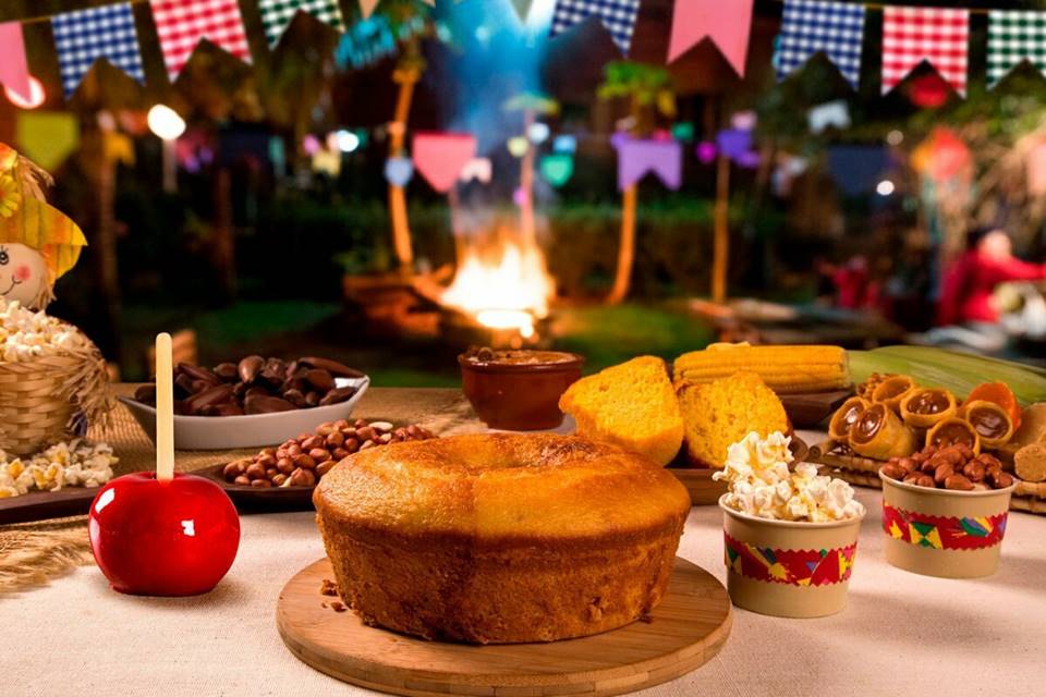 Foto colorida de mesa farta com comidas de festa junina