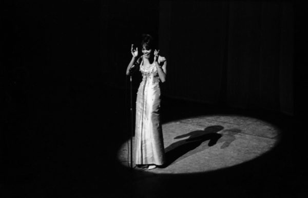 Na imagem preto e branco, uma mulher negra cantando - Metrópoles