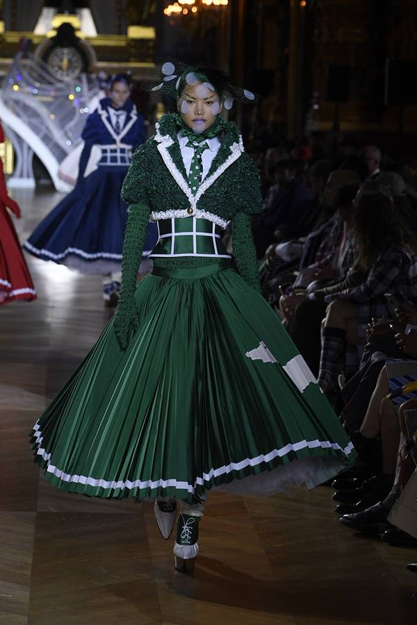 Na passarela da marca Thom Browne, modelo usa look verde. Trata-se de um vestido verde que mistura alfaiataria e saia rodada com plissados -Metrópoles