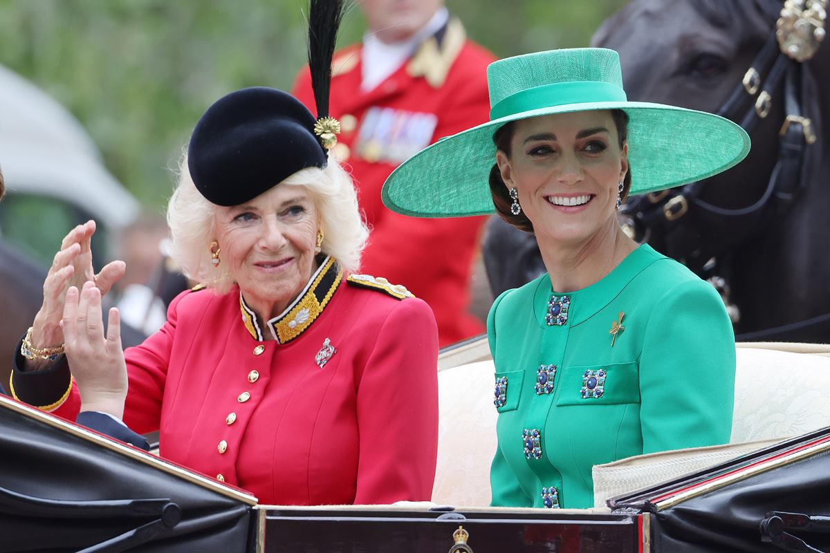 Foto de duas mulheres em uma carruagem. Uma delas está com roupa vermelha e a outra com roupa verde - Metrópoles