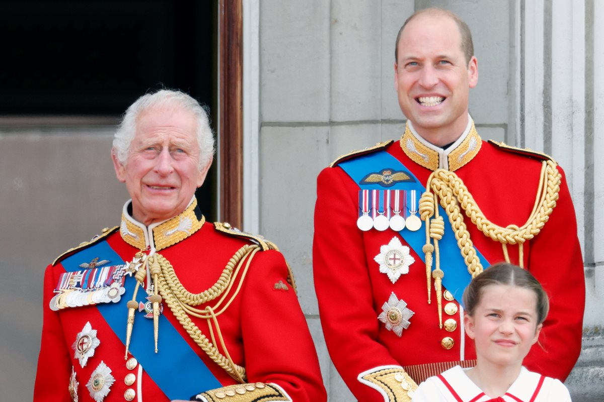 Foto colorida de homem idoso branco e homem branco e calvo com trajes militares da realeza britânica ao lado de menina loira e branca - Metrópoles