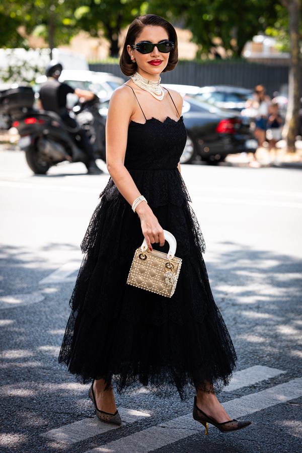 Mulher andando na rua com vestido de renda preto - Metrópoles