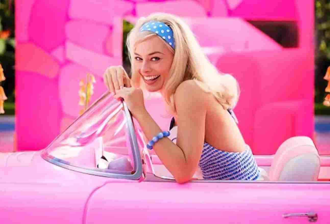 Trecho do filme Barbie. Na imagem, Margot Robbie dirige um carro rosa - Metrópoles