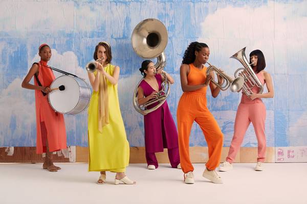 Com roupas coloridas, mulheres tocam instrumentos musicais - Metrópoles