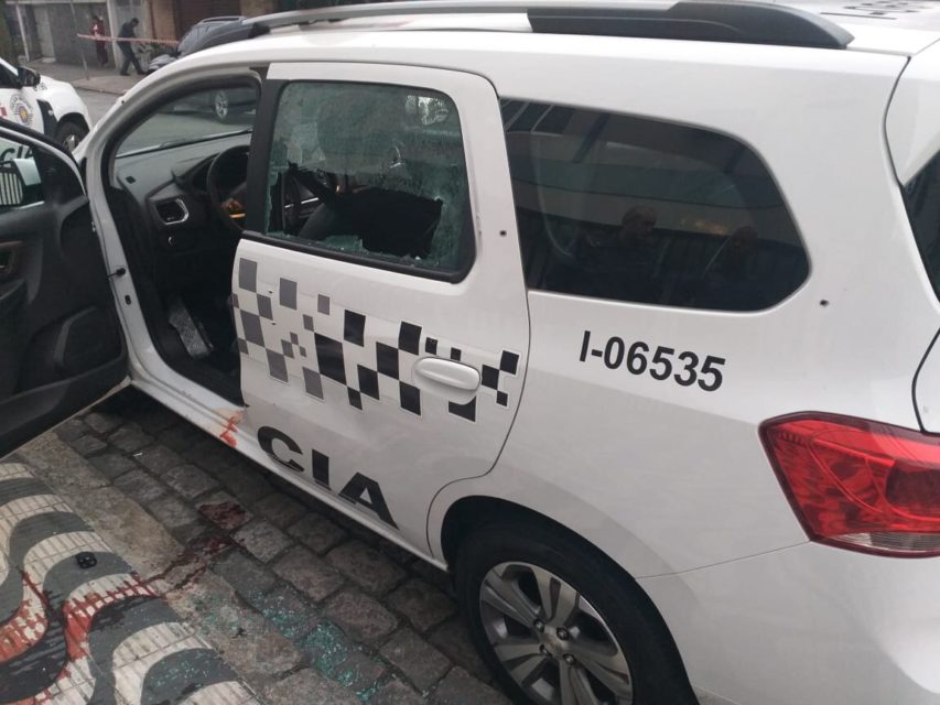 EM foto colorida viarura da PM está com porrta aberta e sangue de policial na calçada - Metrópoles