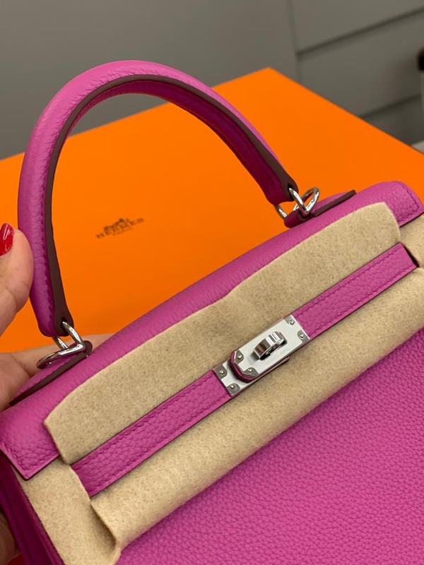 Bolsa rosa com fecho prateada em cima de caixa laranja - Metrópoles