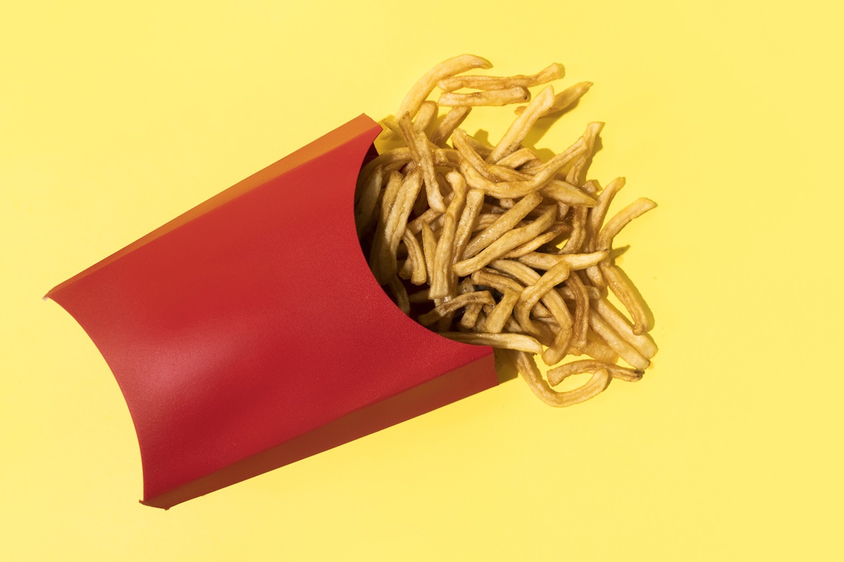 Foto colorida de tiras de batatas fritas dentro de caixa vermelha - Metrópoles