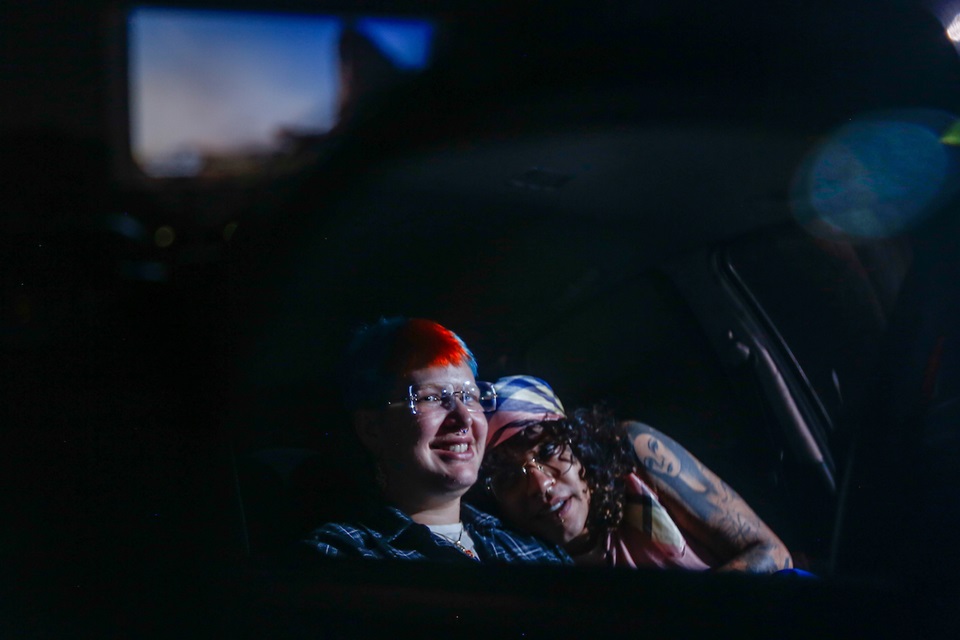 Na foto, um homem e uma mulher se abraçam no carro durante uma sessão do Cine Drive-In - Metrópoles