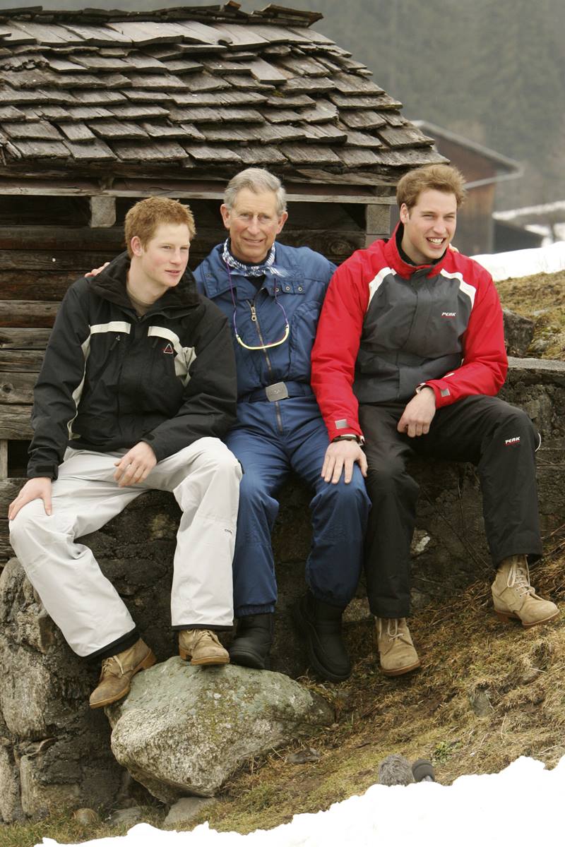 Foto colorida de três homens brancos, sendo o do meio idoso. Ele estão sentados em uma pedra e usam roupas de frio - Metrópoles