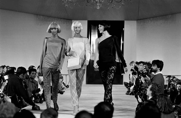 Na imagem em preto e branco, Naomi Campbell, Linda Evangelista e Christy Turlington na passarela. Elas usam perucas de corte chanel e franjas - Metrópoles