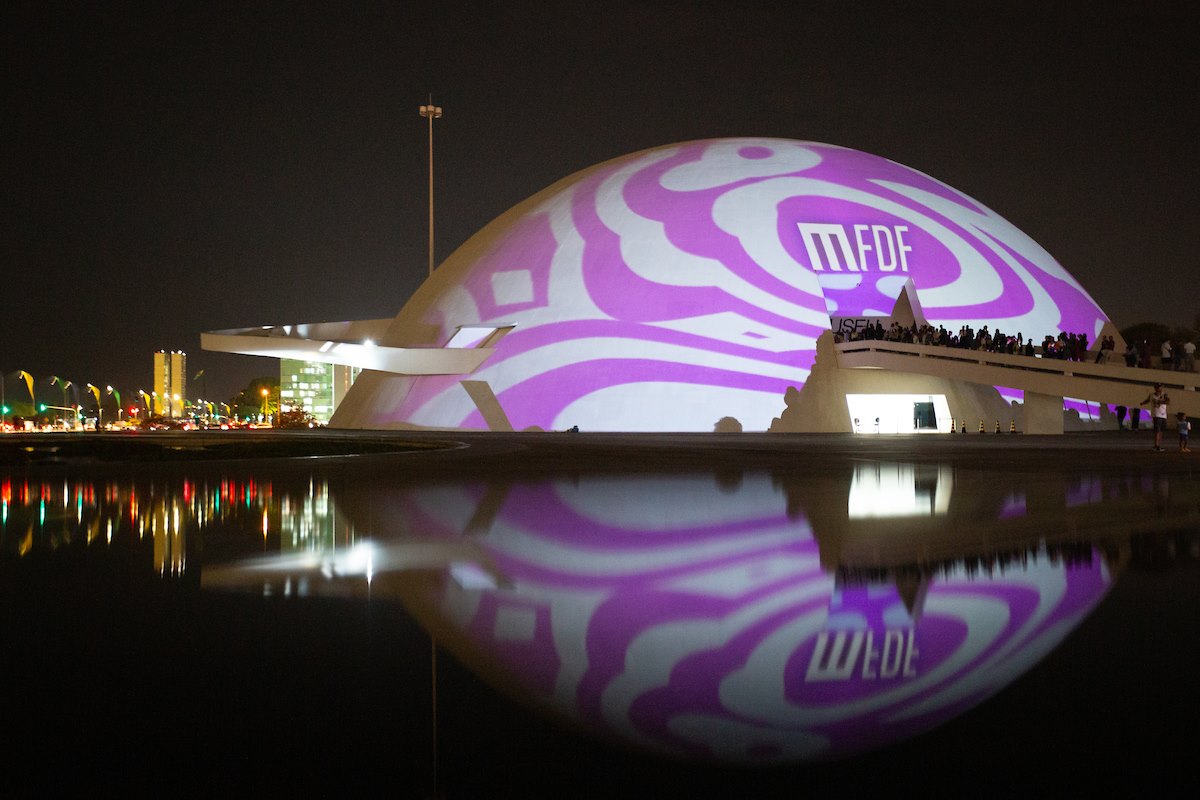 Cúpula do Museu Nacional da República com logo do Metrópoles Fashion & Design Festival projetado e arte em lilás - Metrópoles
