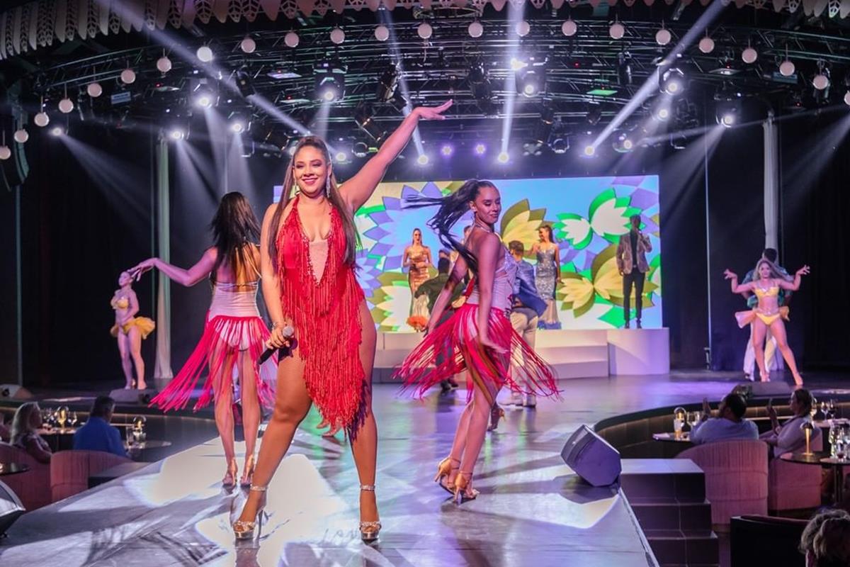 Foto colorida de mulheres em um palco durante um show - Metrópoles