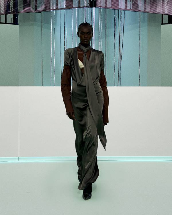 Em desfile de moda, modelo usa vestido cinza longo acetinado - Metrópoles