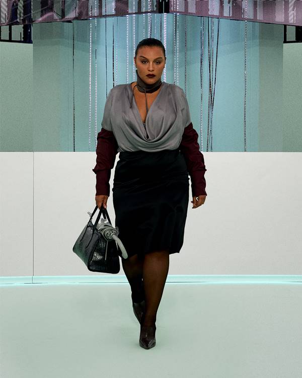 Na passarela de moda, modelo usa saia lápis preta e blusa cinza com mangas bordô - Metrópoles