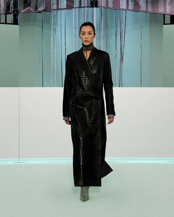 Na passarela de moda, modelo usa sobretudo preto com textura croco - Metrópoles