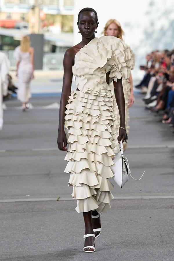 Na passarela de moda, modelo usa vestido creme com detalhes tridimensionais e assimetria - Metrópoles
