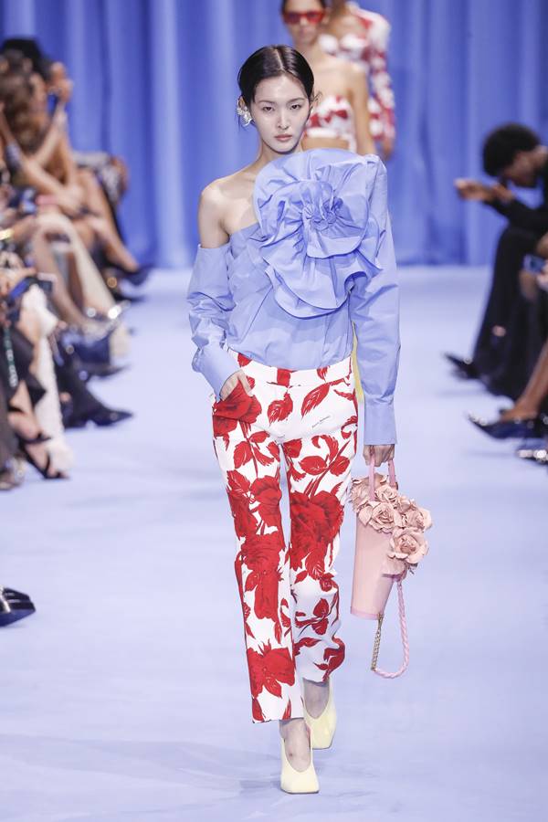 Na passarela de moda, modelo usa camisa azul e calça com estampa em branco e vermelho - Metrópoles