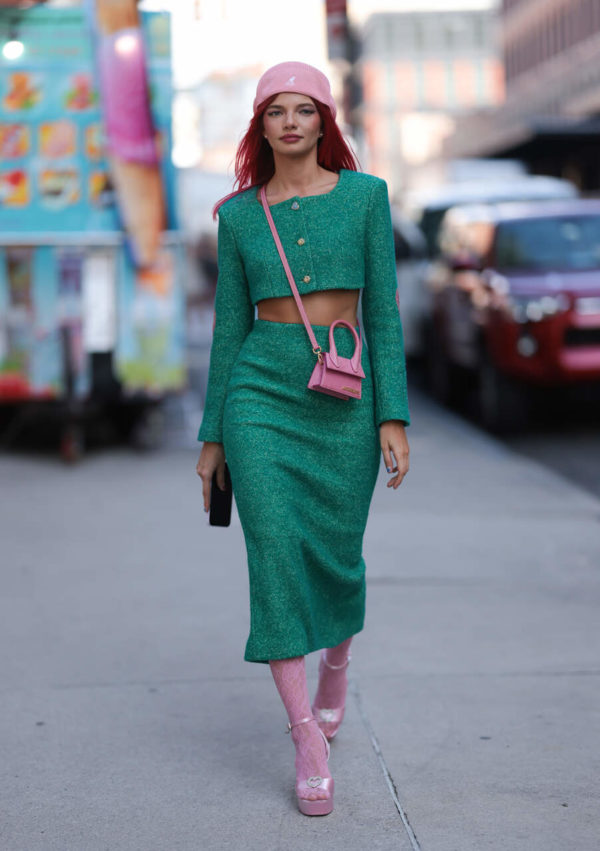 Na imagem com cor, uma mulher com roupas vredes posando para foto - Metrópoles