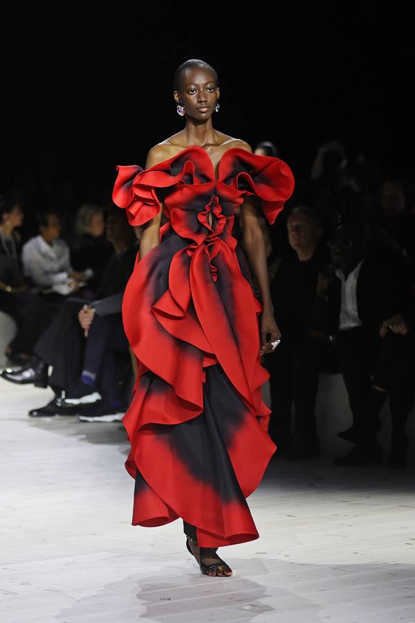 Na passarela de moda, modelo usa vestido vermelho com formato de rosa - Metrópoles