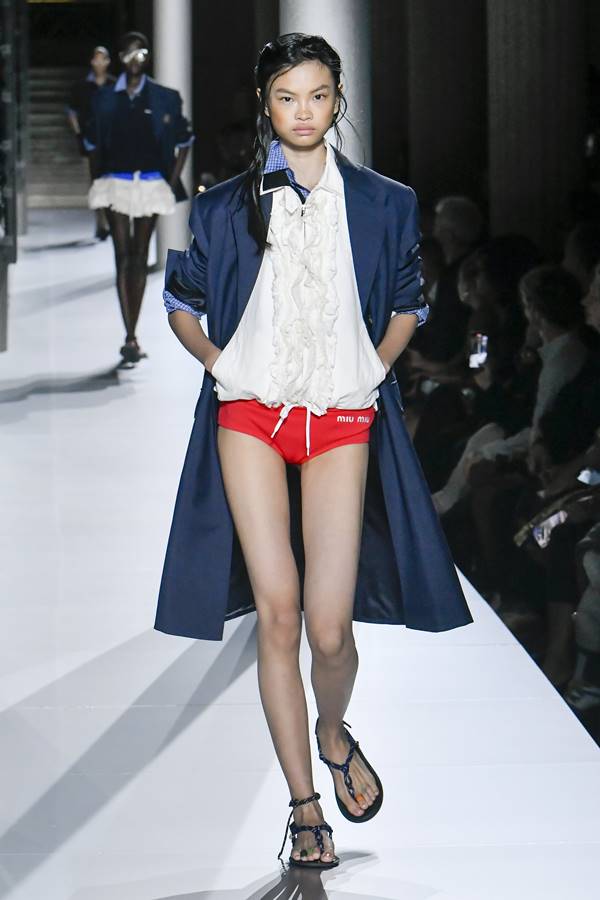 Look com blusa branca, calcinha vermelha e sobretudo azul na passarela de moda da Miu Miu - Metrópoles